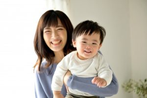 さいたま市南区の一時預かり「たんぽぽのおうち」で、笑顔で子供を抱っこする保育士（イメージ）